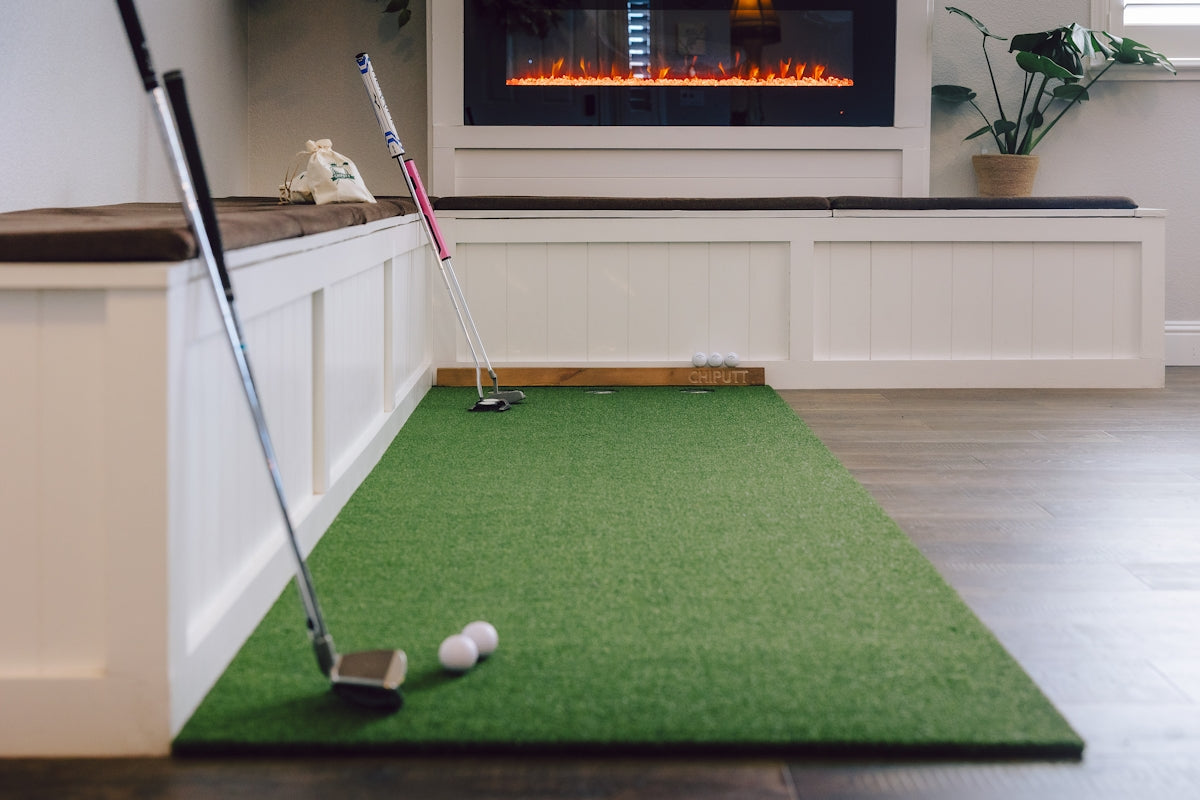Indoor putting green with golf clubs and balls.