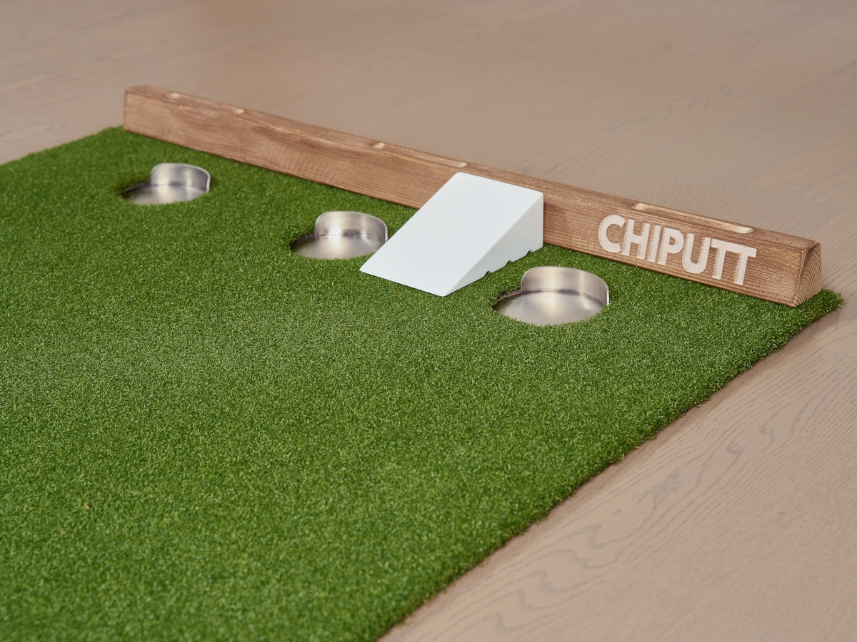 Putting green with three cups and ramp